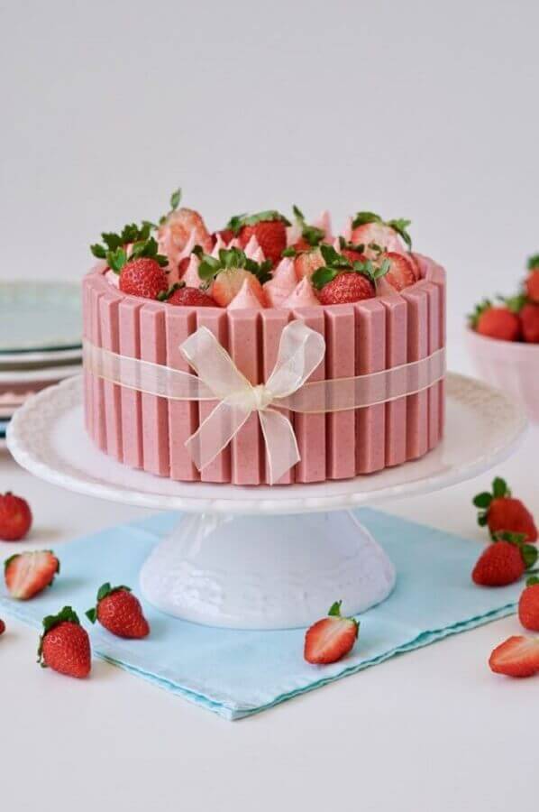 beautiful cake decorated with strawberry sighs and pink chocolate Photo Flamboesa