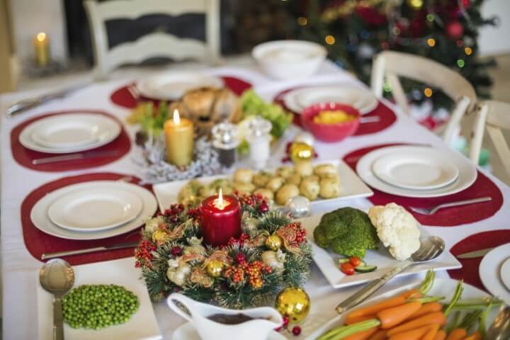 Christmas supper with red sousplat and white tablecloth Photo by Nova24TV