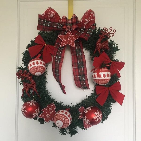 Christmas wreath made with bows, balls and artificial flowers